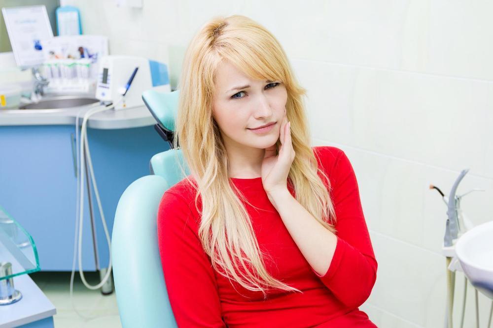 Woman holding her face in pain at the emergency dentist in Winston Salem NC
