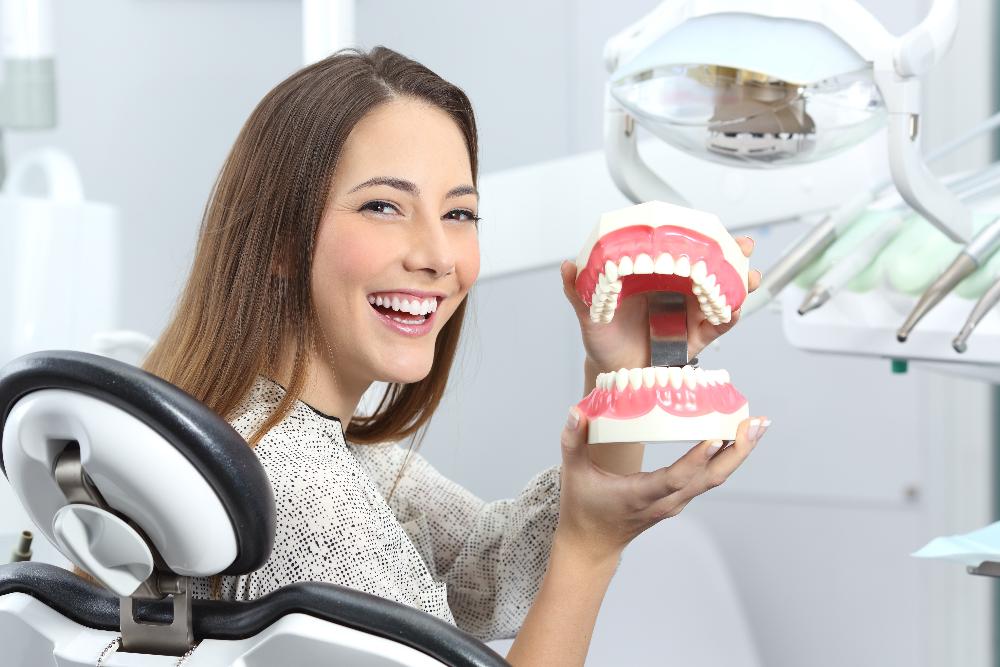 woman holding a dentures model