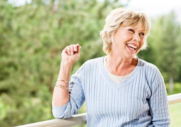 Patient smiling outside with dental implants in Winston Salem NC