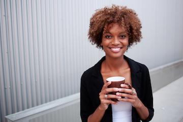 Dental patient smiling and holding a coffee near 27103