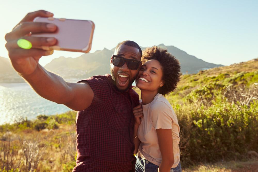 man and woman smiling while taking a selfie