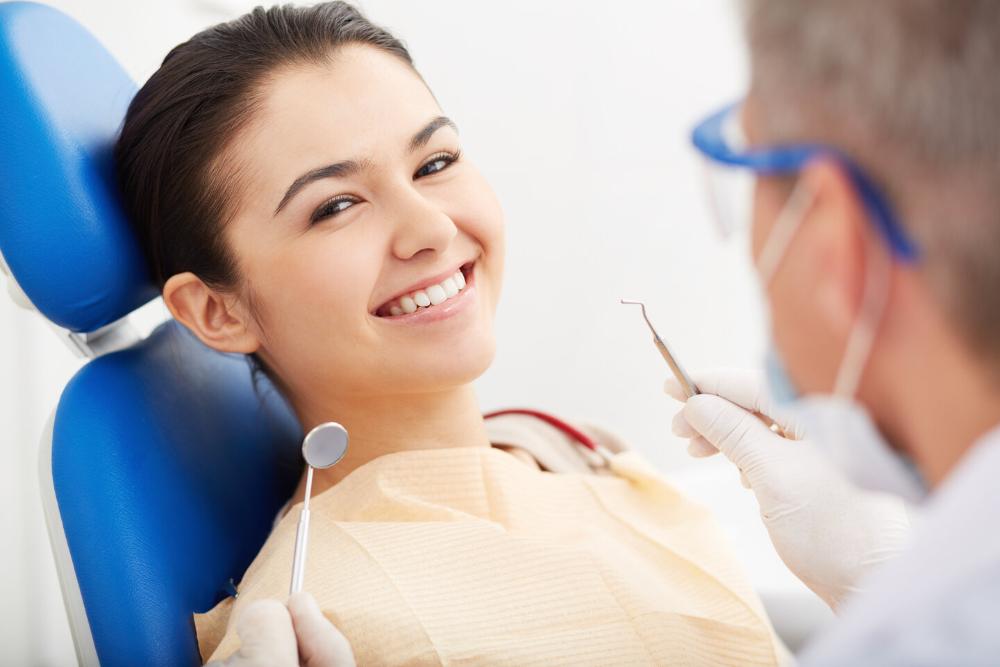 woman smiling in dental chair after cleaning
