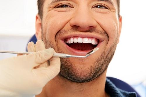 man getting teeth examined with a mouth mirror