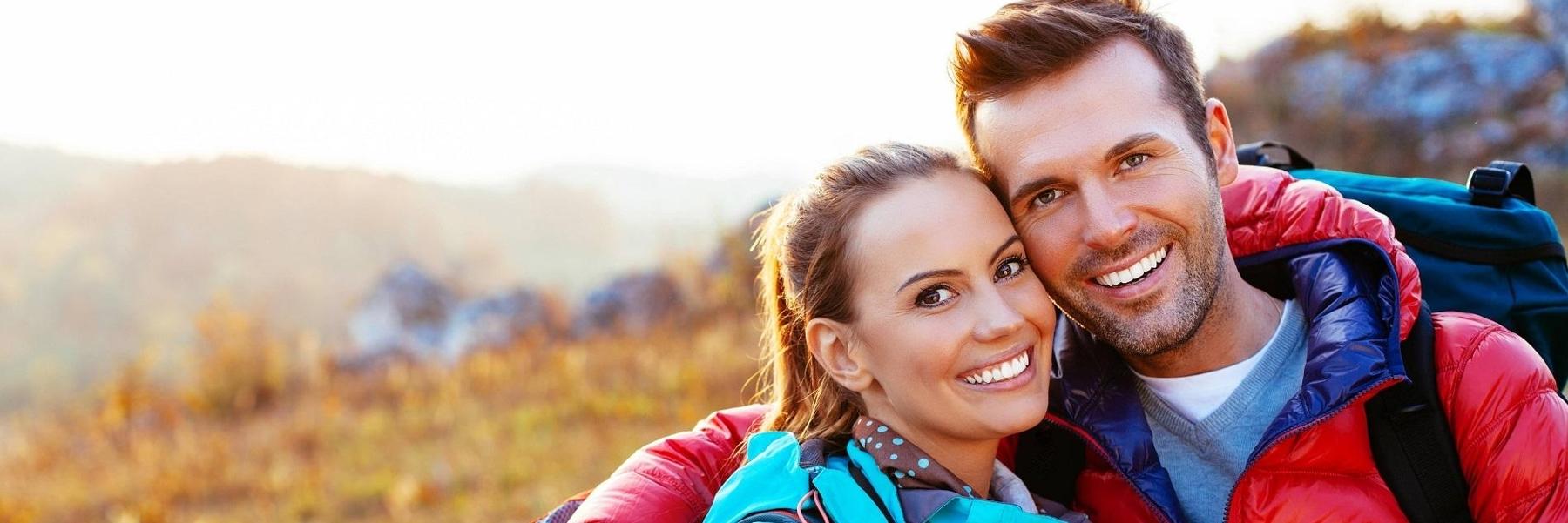 man and woman hiking and smiling