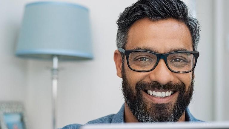 man with glasses smiling with white teeth