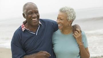 Older couple smiling on a beach