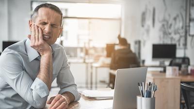 man holding jaw in pain