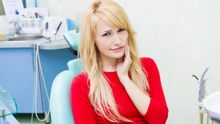 woman holding jaw before root canal