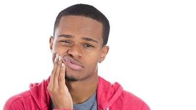 man holding jaw in pain