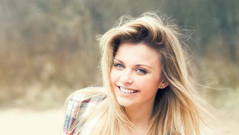woman with blonde hair smiling to the camera
