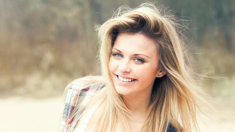 Blonde woman with green eyes smiling