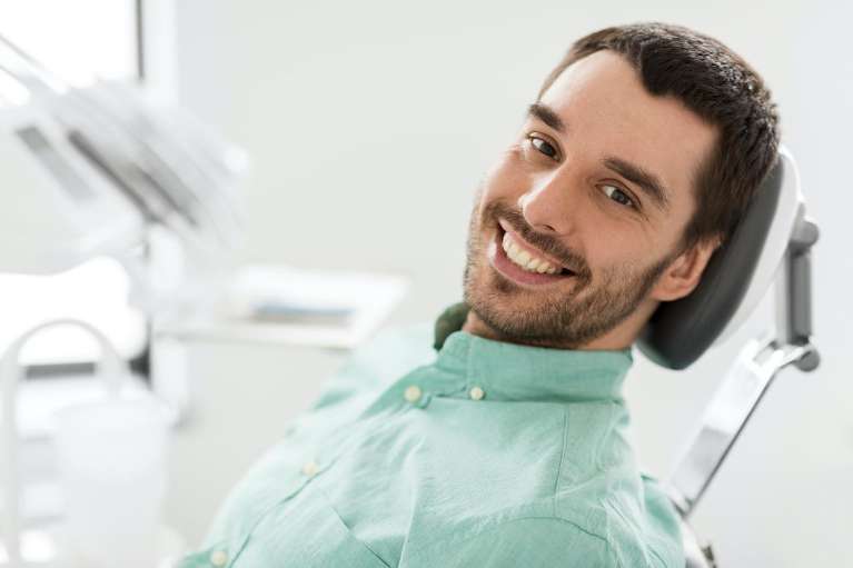 smiling man sitting in a dental chair