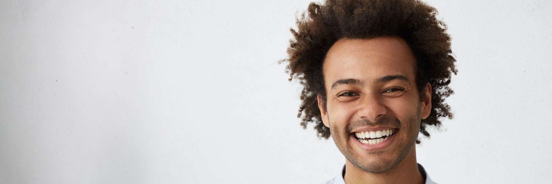 man with curly hair smiling